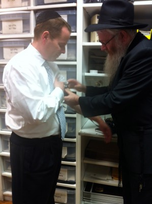Rabbi Mentz placing Jonathan's first piece of Tefillin on him